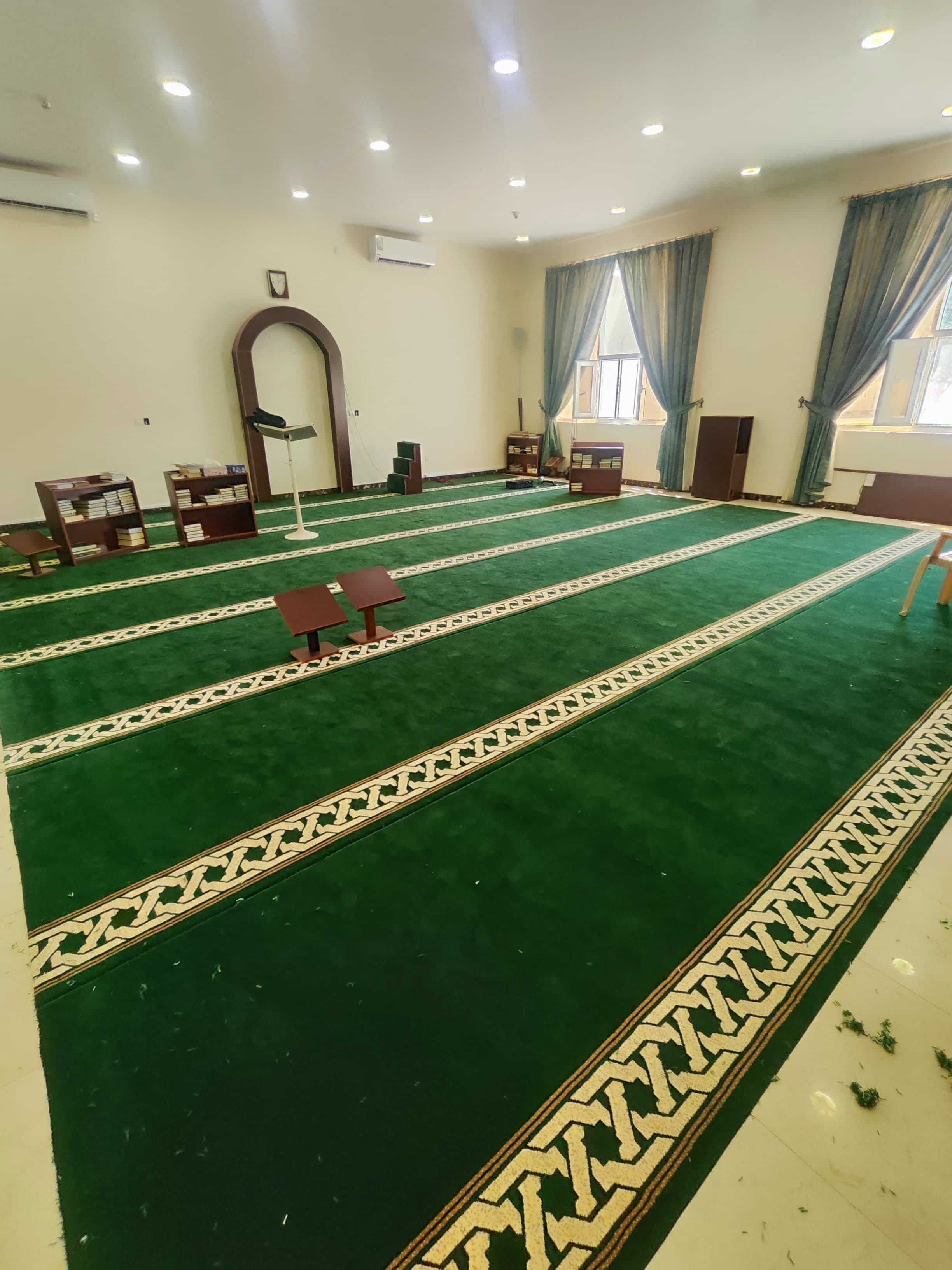 Mosque carpet installation with prayer rows being set to the qiblah in Qatar (view 2)